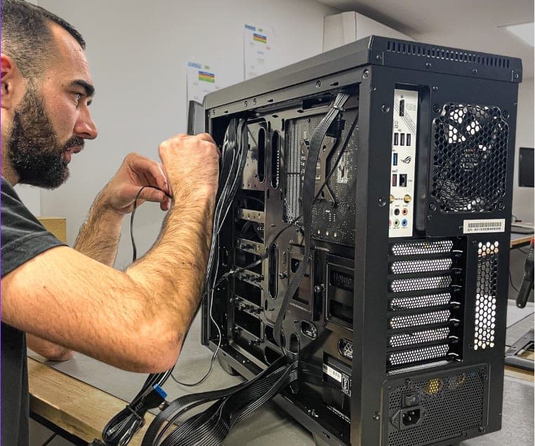 Un technicien NumeriK's câble et met en service un ordinateur lors d'une intervention